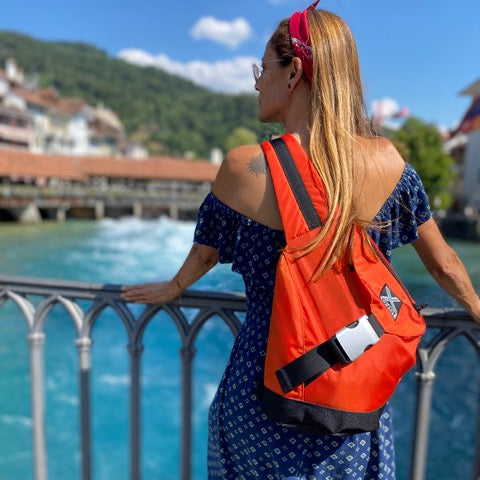 Woman looking at a beautiful river wearing an X-over crossbody backpack